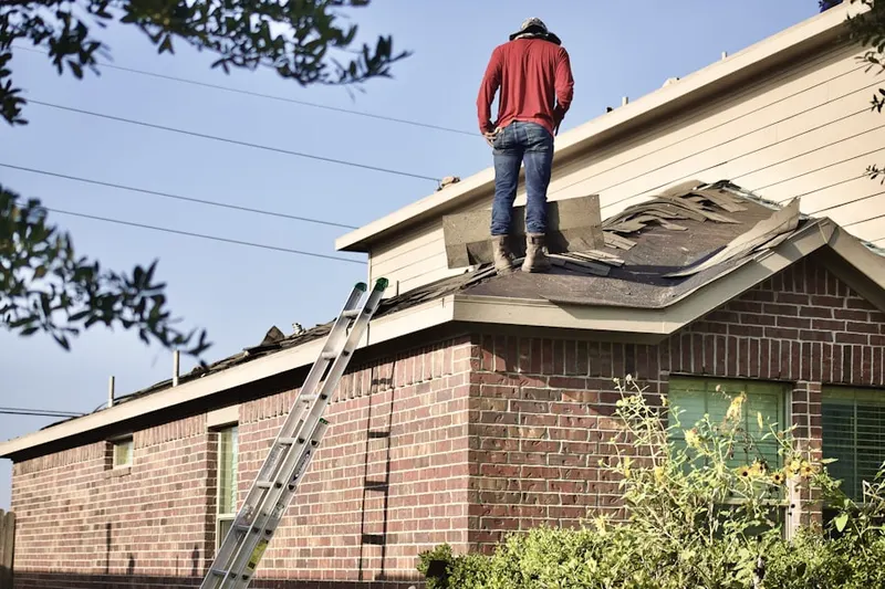 Professional roofer working on a residential roof in Gillespie